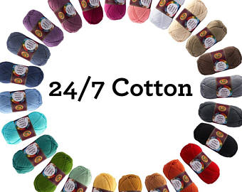 A collection of Lion Brand 24/7 Cotton yarn skeins arranged in a circle, showing various colors.