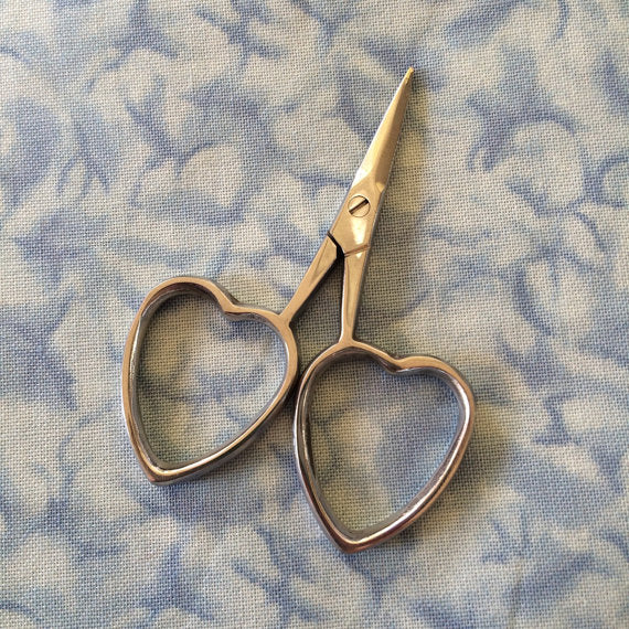 A pair of scissors with heart-shaped handles, lying on a blue patterned surface.

Best sharp scissors for cross stitch Singapore, heart handle scissors for thread, buy boutique embroidery snips onlin
