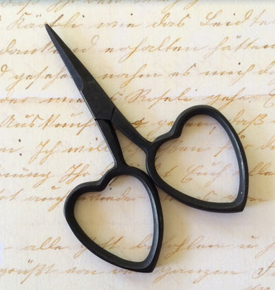 A pair of professional-grade miniature embroidery scissors featuring iconic heart-shaped handles in matt coloured