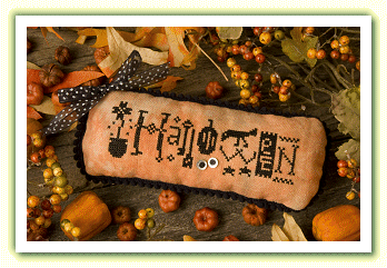 The Lizzie*Kate 'Spooky Eyes' cross-stitch kit featuring a wide-eyed Halloween greeting on swirling orange and black hand-dyed fabric.

Hand-dyed embroidery supplies, artisan Halloween craft