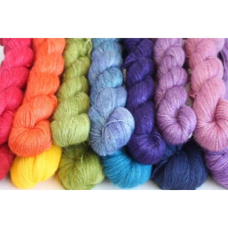 A collection of colorful Malabrigo Baby Silkpaca yarn skeins arranged in a row with a variety of colors including red, green, blue, purple, and yellow.