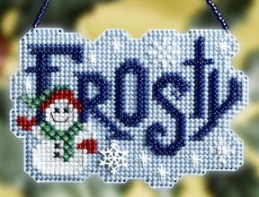 A cross stitch kit depicting a smiling snowman with a blue and green outfit on a blue background with the word 'FROSTY' written in large blue letters.