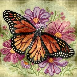 A cross stitch kit depicting a butterfly with orange and black colors, surrounded by purple and pink floral designs on a green background.

The completed 5x5 Winged Monarch project framed in a simple black wood frame, highlighting the rich colors and textures