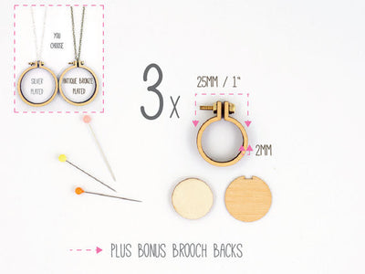 Packaging of Dandelyne miniature embroidery hoop kit with contents displayed, including three hoops with attached necklace chains and brooch backs.

Close-up of the 1-inch Dandelyne hoop next to a thimble for scale, highlighting the precision-cut wood and tiny hardware