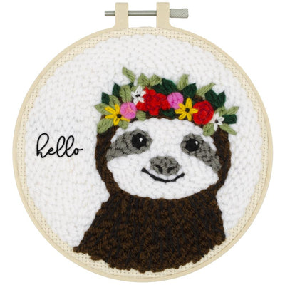 Embroidery hoop kit depicting a sloth with a floral wreath and the text 'Hello' on a white background, framed in a 6-inch plastic hoop.