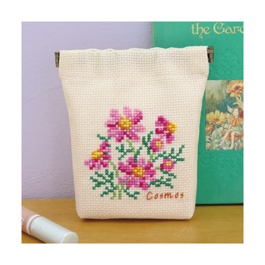 An Olympus Cosmo cross stitch kit for a floral-themed snap pouch. The image shows the soft, 100% cotton fabric with a pre-marked grid, a palette of vibrant Cosmo embroidery threads, a metal snap-top frame, and a clear symbol-based pattern chart, all made in Japan