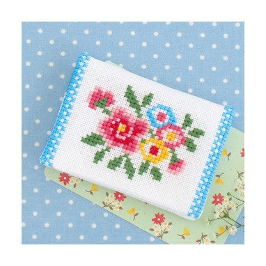 A cross stitch kit depicting a floral pattern, likely to be used for making a card case or tissue pouch.