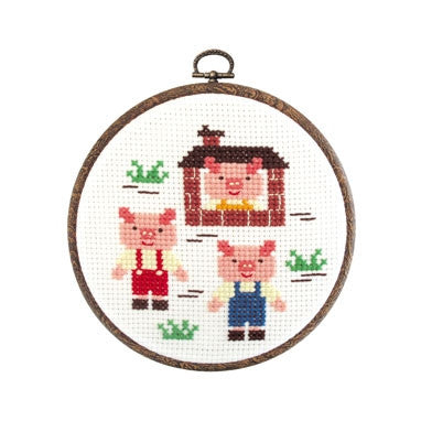 Fairy Tale Cross Stitch for Kids.
Cross stitch kit depicting three small piglets in a fairy tale setting, with a embroidery hoop, Aida cloth, and colored threads.

beginner needlework kit Singapore, Three Little Pigs craft for children