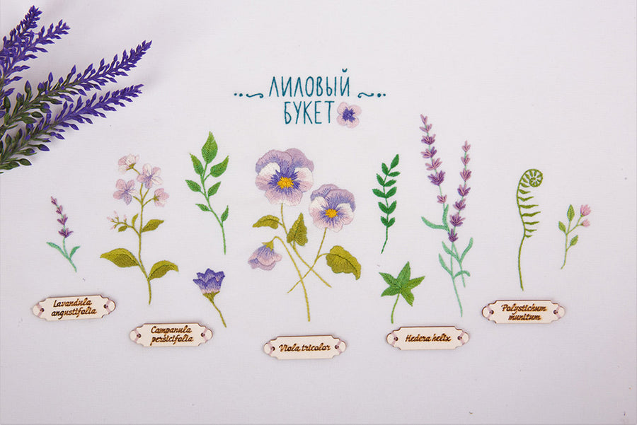 A series of embroidered violet flower designs with their scientific names, completed in different colors on a white background, with a label in the background providing information about the kit.