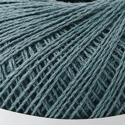 A 40g ball of Pierrot Chanvre, a 100% linen yarn made in Japan, showing its smooth, natural fiber texture and slight lustrous sheen in antique blue