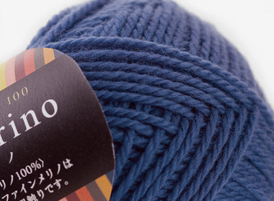Close-up of premium Japanese Pierrot Fine Merino wool, showcasing the smooth, anti-pilling texture and fine weight suitable for intricate knitting deep blue