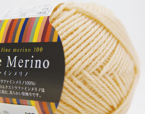 A 30g donut-style ball of Pierrot Fine Merino yarn. The image showcases the smooth, tightly spun plies of 100% Extra Fine Merino wool, reflecting the high-quality Japanese craftsmanship and the soft, matte finish characteristic of premium boutique yarns in cream colour