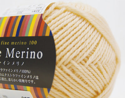 A 30g donut-style ball of Pierrot Fine Merino yarn. The image showcases the smooth, tightly spun plies of 100% Extra Fine Merino wool, reflecting the high-quality Japanese craftsmanship and the soft, matte finish characteristic of premium boutique yarns in cream colour