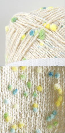 Pierrot Framboise yarn in Citrus with multicolored speckles, arranged on a surface with labels indicating the brand and type.