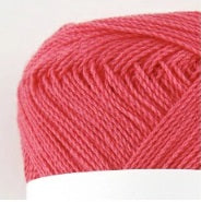 A compact ball of New Shine Cotton by Pierrot, highlighting the way light reflects off the polished cotton strands, characteristic of high-quality Japanese yarn in coral pink colour