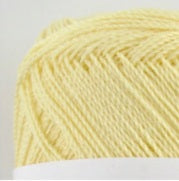 A compact ball of New Shine Cotton by Pierrot, highlighting the way light reflects off the polished cotton strands, characteristic of high-quality Japanese yarn in cream yellow colour