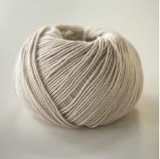 A 40g ball of Pierrot Orgabits One, a 100% organic cotton yarn made in Japan, showing its smooth matte texture in Clear Beige