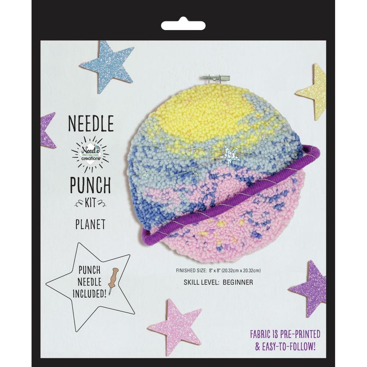 The kit includes bright acrylic yarn, a 100% cotton fabric with a pre-printed planetary pattern, an 8-inch locking plastic embroidery hoop, a punch needle tool, and a needle threader. The final piece displays a textured, 3D effect across the celestial rings and planet surface