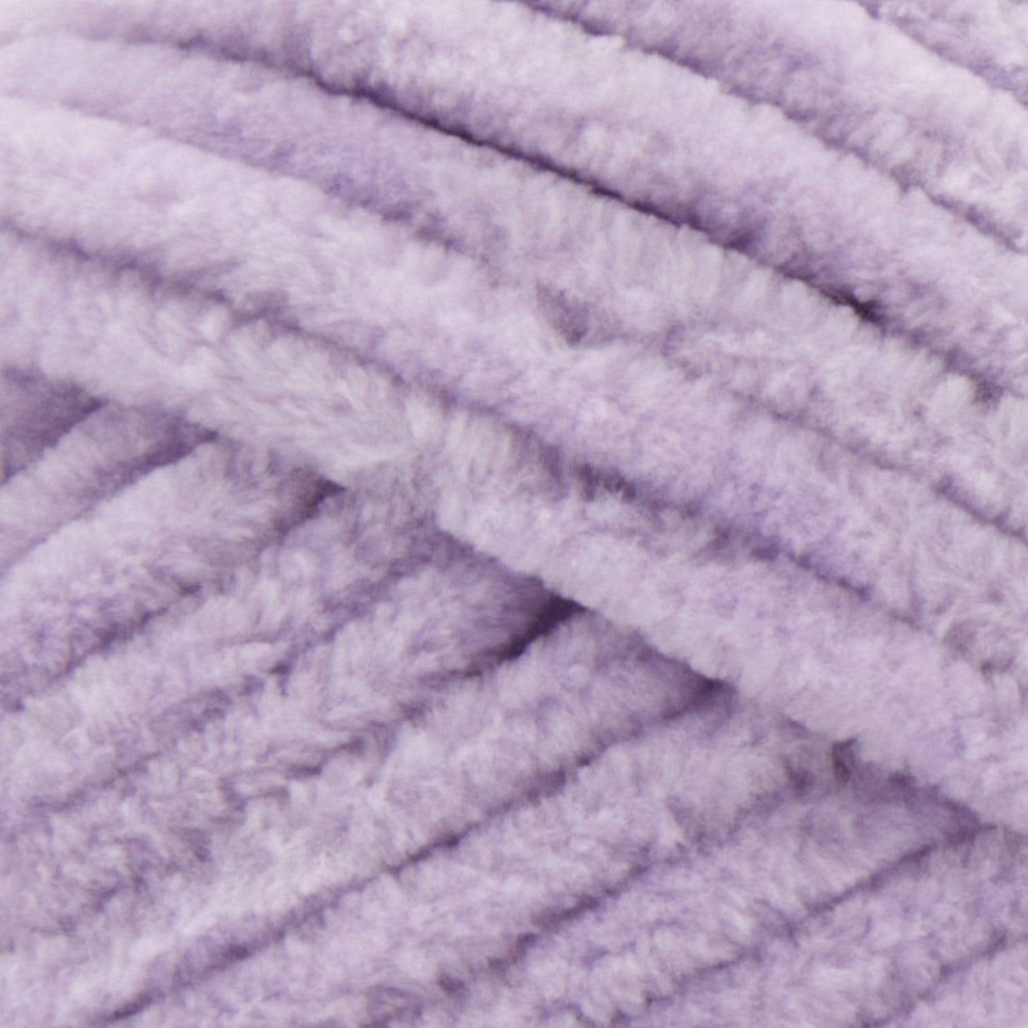 A plush skein of Premier Parfait Chunky chenille yarn in Lilac showcasing its thick, velvety texture. The image highlights the super bulky #6 weight and the vibrant matte finish of the polyester fibers, ideal for creating soft toys, cozy blankets, and kid-friendly crochet projects