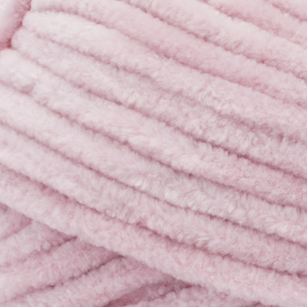 Close-up of Premier Parfait Chunky polyester yarn, highlighting the dense, plush pile and vibrant color in rose pink colour