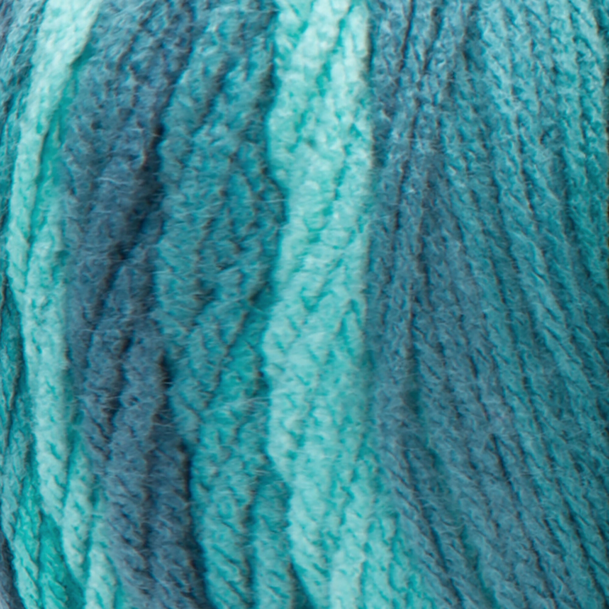 A large 283-gram skein of Red Heart Super Saver Ombre yarn, showing a beautiful gradient transition from a light tint to a deep, saturated shade Green to Teal color. The yarn has a classic 4-ply twist and a soft matte finish, perfect for creating shawls, blankets, and garments with a natural ombré effect