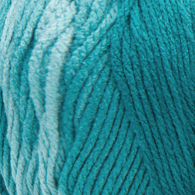 A large 283-gram skein of Red Heart Super Saver Ombre yarn, showing a beautiful gradient transition from a light tint to a deep, saturated shade of teal color. The yarn has a classic 4-ply twist and a soft matte finish, perfect for creating shawls, blankets, and garments with a natural ombré effect
