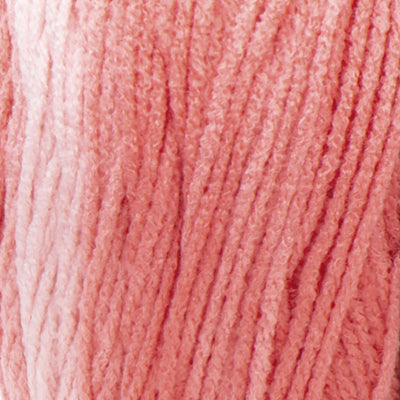 A large 283-gram skein of Red Heart Super Saver Ombre yarn, showing a beautiful gradient transition from a light tint to a deep, saturated shade of coral color. The yarn has a classic 4-ply twist and a soft matte finish, perfect for creating shawls, blankets, and garments with a natural ombré effect