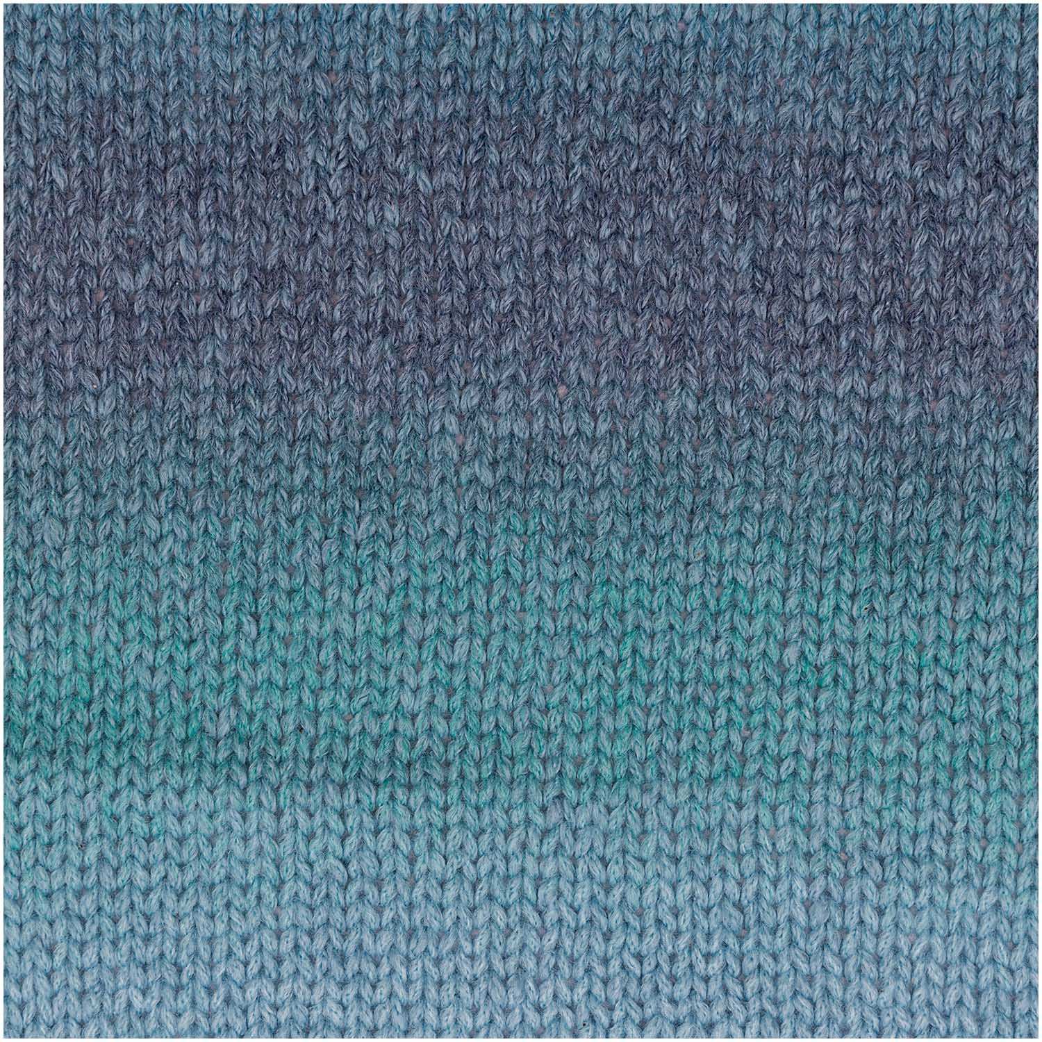 A ball of Rico Fashion Cotton Light & Long DK showing a beautiful gradient transition from dark to light hues of blue over a knitted piece.