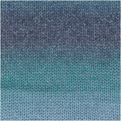 A ball of Rico Fashion Cotton Light & Long DK showing a beautiful gradient transition from dark to light hues of blue over a knitted piece.