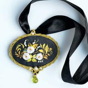"A specialized wearable embroidery kit from Riolis for creating a floral-themed pendant. The design features a colorful floral motif with 3D ribbon petals, accented by Anchor stranded cotton and three varieties of beads, including sparkling glass beads. The kit includes a fabric panel with a pre-printed picture for easy stitching, a square metal pendant frame, two needles, and full instructions. The finished pendant measures 2.75 by 2.75 inches."