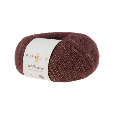 A skein of Rowan Kidsilk Haze yarn in dark brown color with a label wrapped around it.