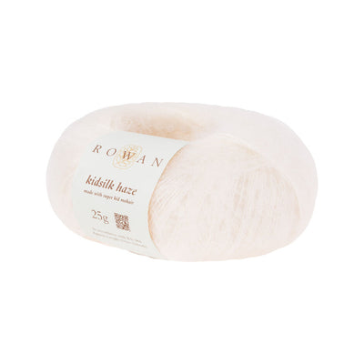 A skein of Rowan Kidsilk Haze yarn in cream color with a label wrapped around it.