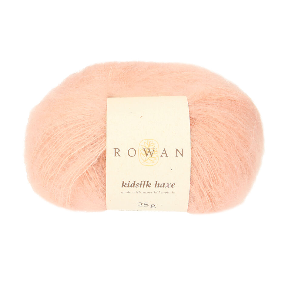 A skein of Rowan Kidsilk Haze yarn in a light pink color with a label wrapped around it.