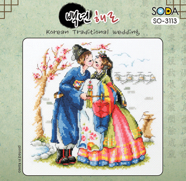 A square-format cross-stitch kit from SODA (Korea) featuring a traditional Korean wedding scene. The design shows a bride and groom in colorful, detailed hanboks surrounded by symbolic cultural motifs. The kit includes 14-count white Aida cloth, full skeins of DMC embroidery threads, and a needle. The finished design measures 19 cm by 19 cm