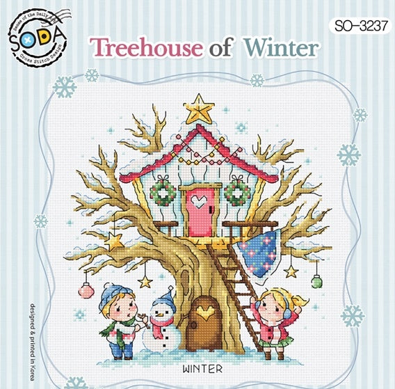 A cross stitch kit depicting a whimsical winter scene with a tree house, children, and winter decorations.