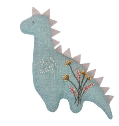 A finished Aroma Dinosaur Animal tucked into a drawer of folded linens, highlighting its use as a stylish and fragrant sachet with the words" it is magic" and embroidery flowers on the front