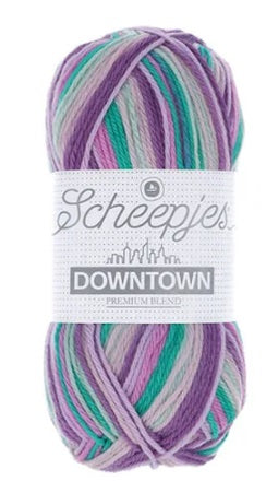 A skein of Scheepjes Downtown self-striping yarn in multicolor, predominantly in shades of purple, pink, mint, and green.