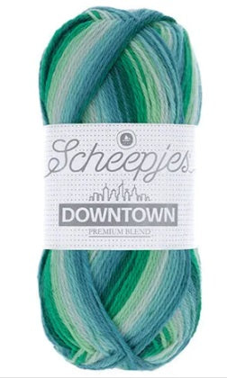 A skein of Scheepjes Downtown self-striping yarn in multicolor, predominantly in shades of green.