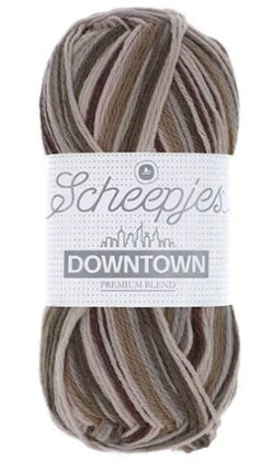 A skein of Scheepjes Downtown self-striping yarn in multicolor, predominantly in shades of brown