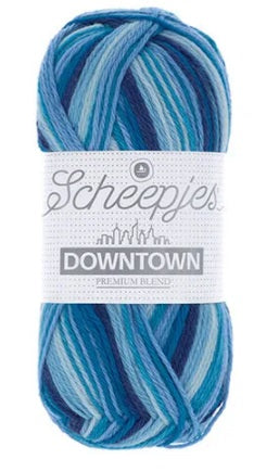 A skein of Scheepjes Downtown self-striping yarn in multicolor, predominantly in shades of blue
