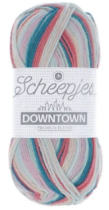 A skein of Scheepjes Downtown self-striping yarn in multicolor, predominantly in shades of Coral, Teal, and mint.