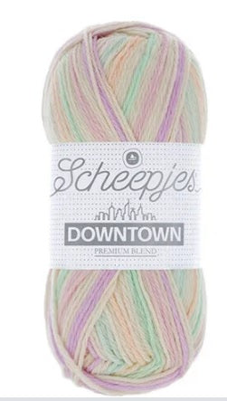 A skein of Scheepjes Downtown self-striping yarn in multicolor, predominantly in shades of pink, lilac and mint. Pastel shades