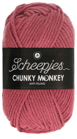 A lush, oversized ball of Scheepjes Chunky Monkey Aran yarn in a vibrant solid color, featuring a thick, smooth twist and a subtle silky sheen in salmon colour