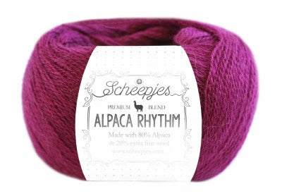 A skein of Scheepjes Alpaca Rhythm yarn in a multicolor pattern, with the brand and product name displayed on the label.