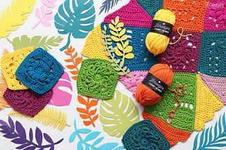 Scheepjes Chunky Monkey Yarn in various colors knitted into a patterned fabric, with some yarn balls and knitted items displayed on a background with leaf patterns.