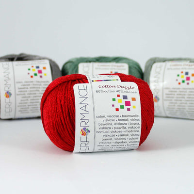 A 50g skein of Cotton Dazzle yarn in a scarlet red vibrant shade, showcasing the subtle reflective shimmer and smooth plied texture of the cotton-viscose blend
