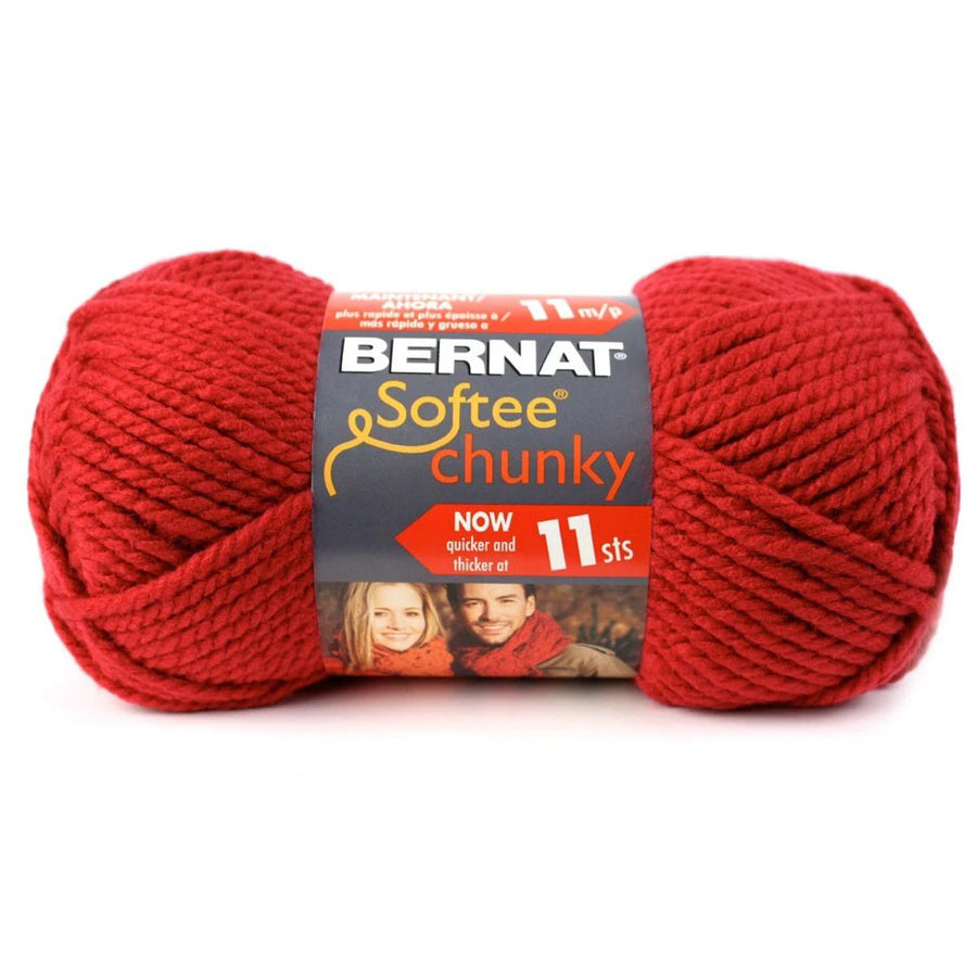 A skein of Bernat Softee Chunky yarn in red color with packaging details visible.
