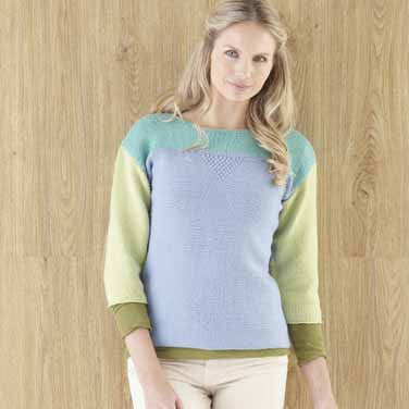 "A finished knitted piece from the booklet styled with casual chinos, illustrating the 'effortlessly stylish' weekend look of the collection