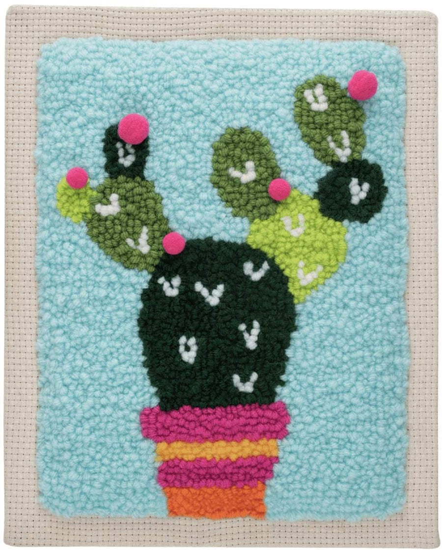 A complete 'Cactus' punch needle starter kit by Trimits. The kit includes a 20.32 x 25.4 cm (8x10 inch) fabric panel pre-stretched on a wooden frame with a printed cactus outline. Also included are vibrant green and terracotta yarns, a punch needle tool, a needle threader, and a large color reference image