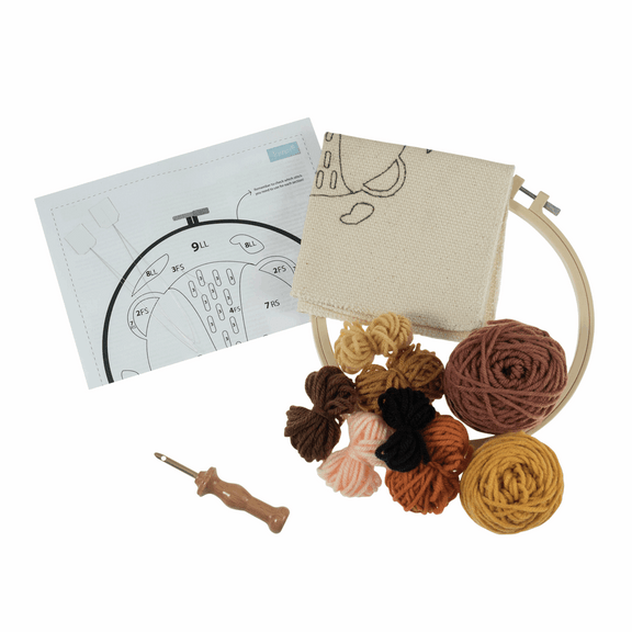 The kit includes a 20.32cm (8-inch) non-slip plastic hoop, pre-printed 11-count fabric featuring a friendly lion face with a large mane, vibrant yellow and orange yarns, a punch needle tool, and a needle threader.